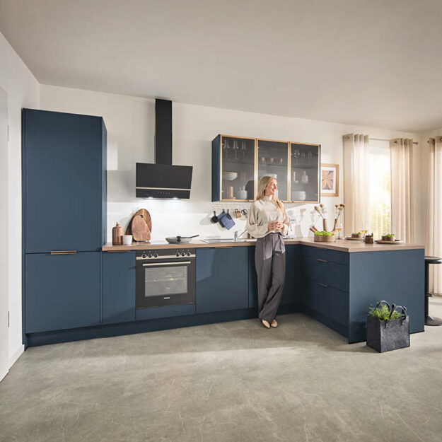 Klassische Häcker Küche in Blau mit Ecklösung und Holzarbeitsplatte im Küchenstudio Stürzenberger.